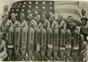 Группа чинов амер.армии на фоне авиабомб с флагами.