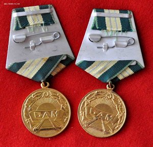Две медали БАМ с клеймами слева и справа.
