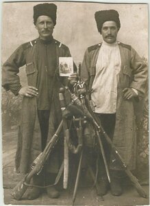Фотография братьев казаков с семейной фотографией и оружием.